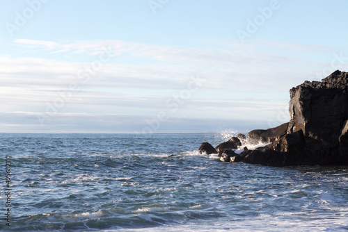 waves hitting rocks on the shore and beach