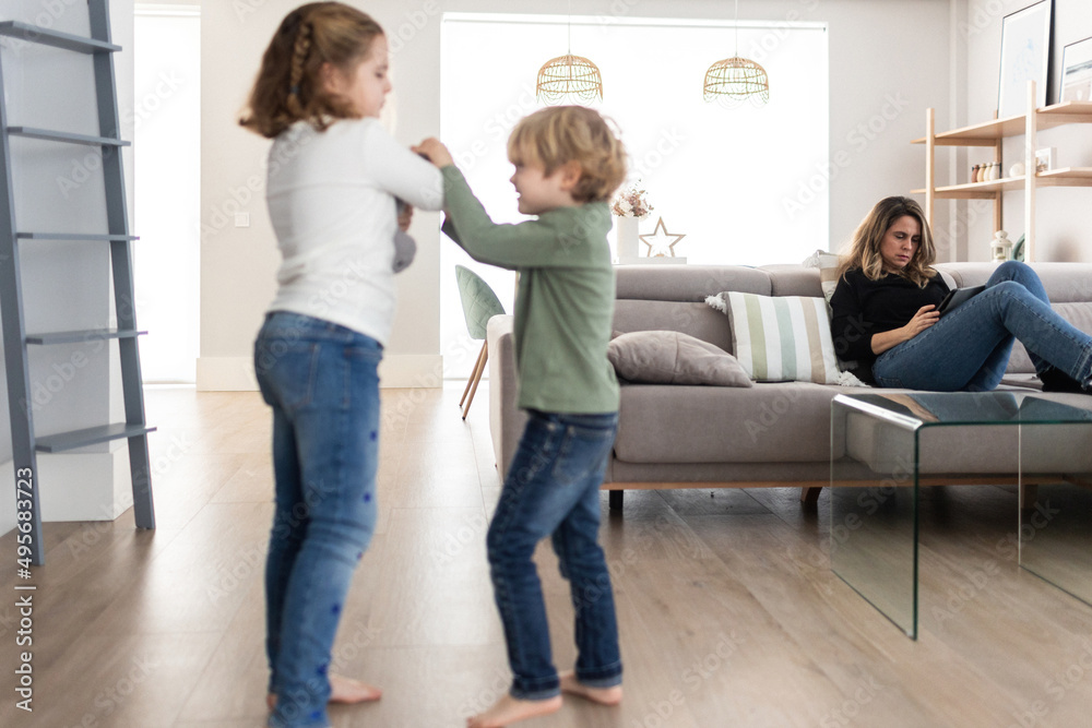 Sibling fighting over toy in living room Sibling fighting over toy in living room