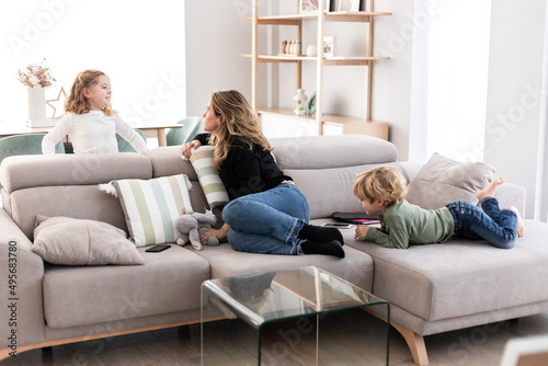 Mother spending time with children in living room photo