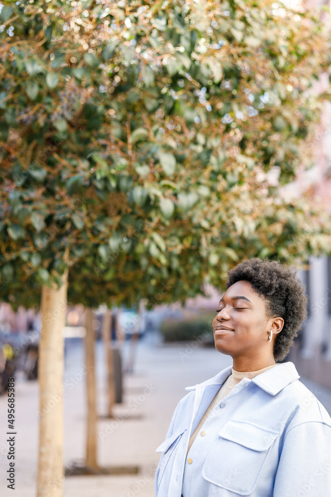 Positive black woman with closed eyes on street Positive black woman with closed eyes on street