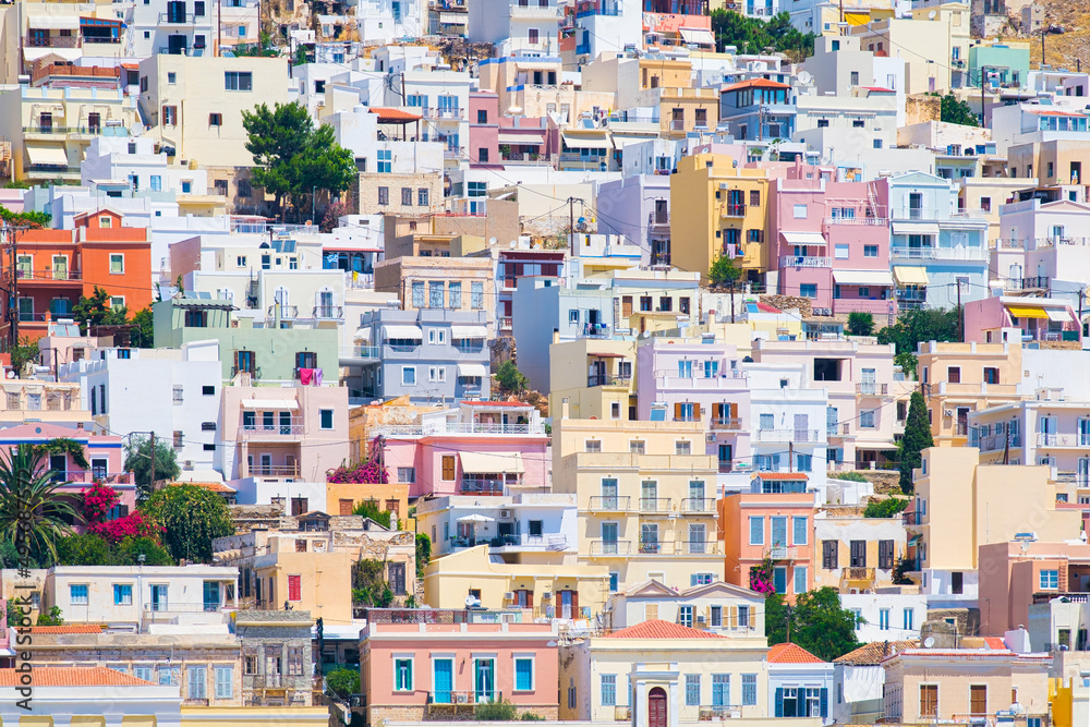 Ermoupolis town, Greece. A town on the side of a mountain. Houses and streets in Greek architecture. Photography for travel and adventure. Cascading arrangement of buildings on the hillside.