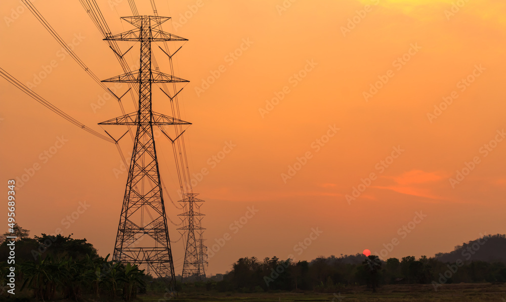 Power poles and power transmission lines at sunset, high voltage poles supply power in a long distance.