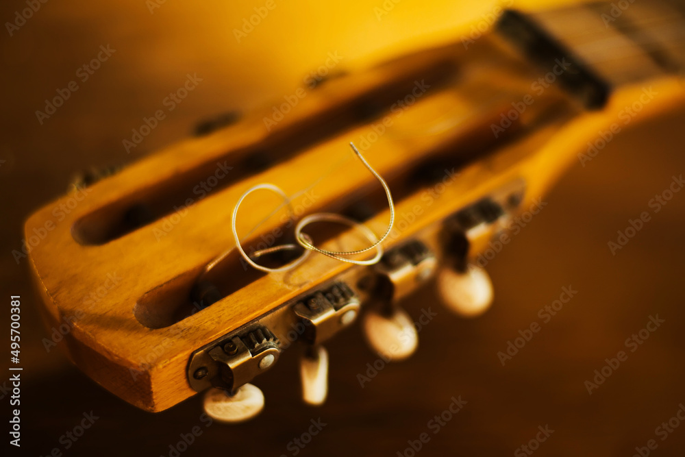 Naklejka premium The fretboard of an old vintage guitar with metal strings on a sunny day. A musical instrument. Creation. Solfeggio.