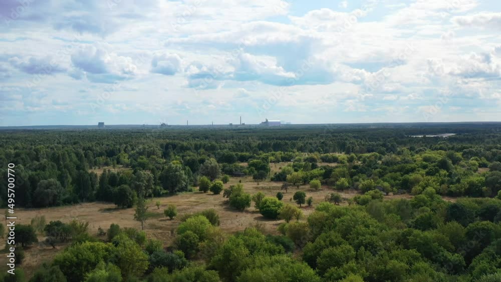 Aerial view of the valley and forest with Reactor 4 Sarcophagus of the Chernobyl Nuclear Powerplant in the distance. Filmed in the summer of 2021 in Chernobyl Ukraine. Aerial view of the valley and forest with Reactor 4 Sarcophagus of the Chernobyl Nuclear Powerplant in the distance. Filmed in the summer of 2021 in Chernobyl Ukraine.