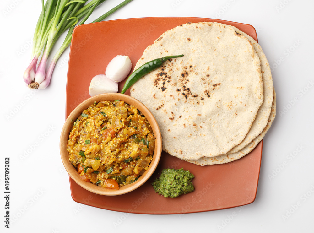 indian village food roasted egg plant and bhakri or Indian flat bread Jowar Roti served with