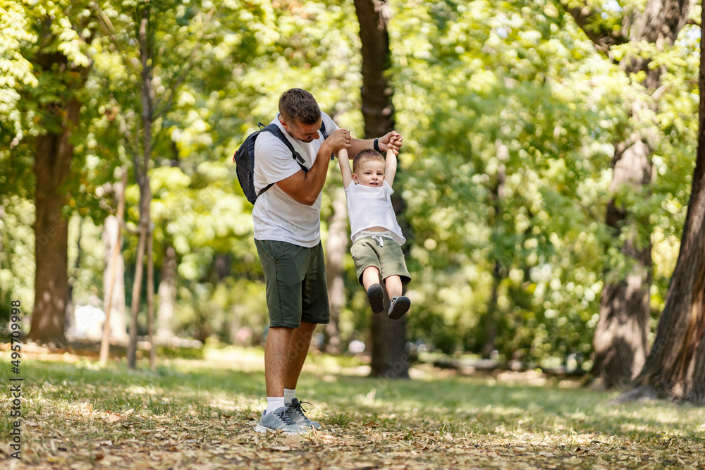 Father playing fun game in nature with his son.