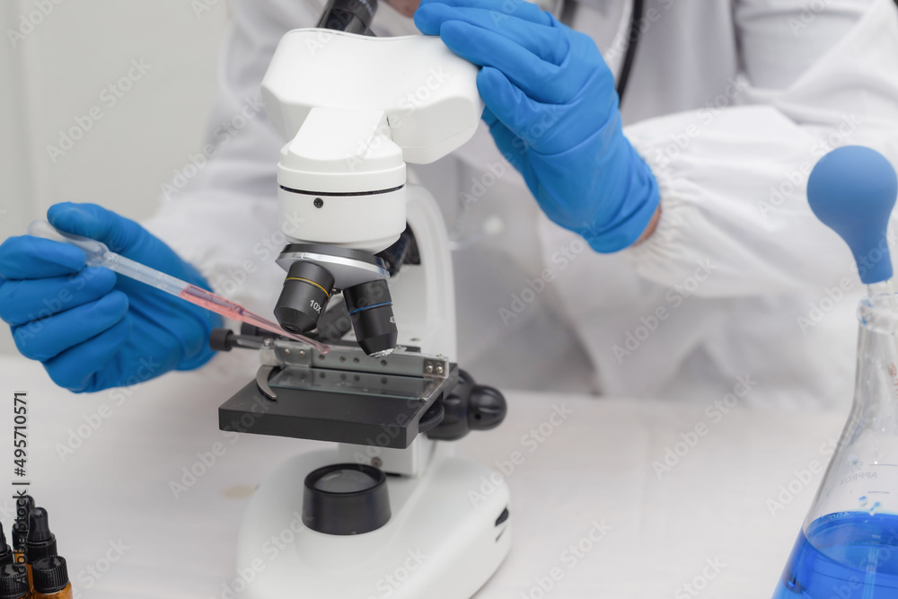 men in a laboratory microscope with microscope slide in hand men in a laboratory microscope with microscope slide in hand