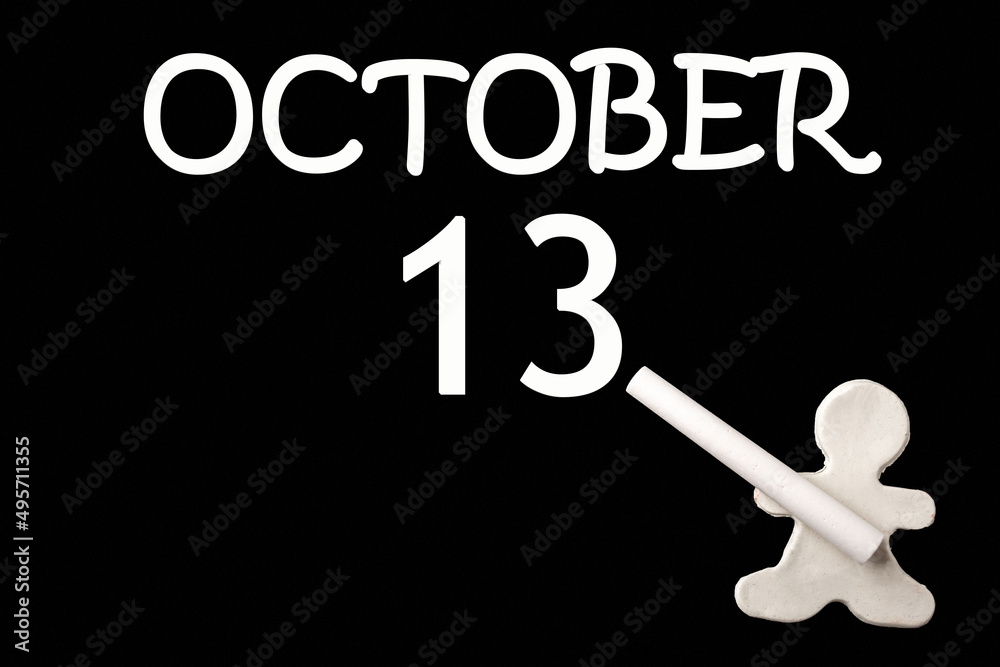 A small white plasticine man writing the date 13 October on a black board. Business concept. Education concept. A small white plasticine man writing the date 13 October on a black board. Business concept. Education concept.