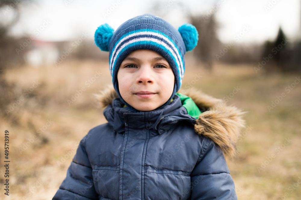 Portrait of little adorable boy in warm clothes against rural background in spring Portrait of little adorable boy in warm clothes against rural background in spring