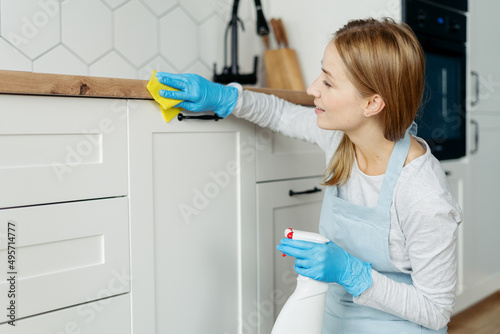 Female wearing in apron cleaning table on kitchen
