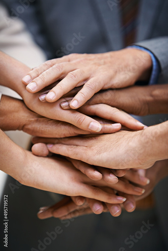 We pass our success from one to another. Shot of a group of businesspeople putting their hands together in unity.