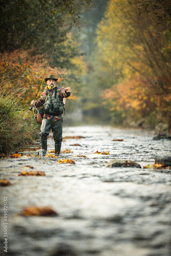 Fly fisherman fly fishing on a splendid mountain river Fly fisherman fly fishing on a splendid mountain river