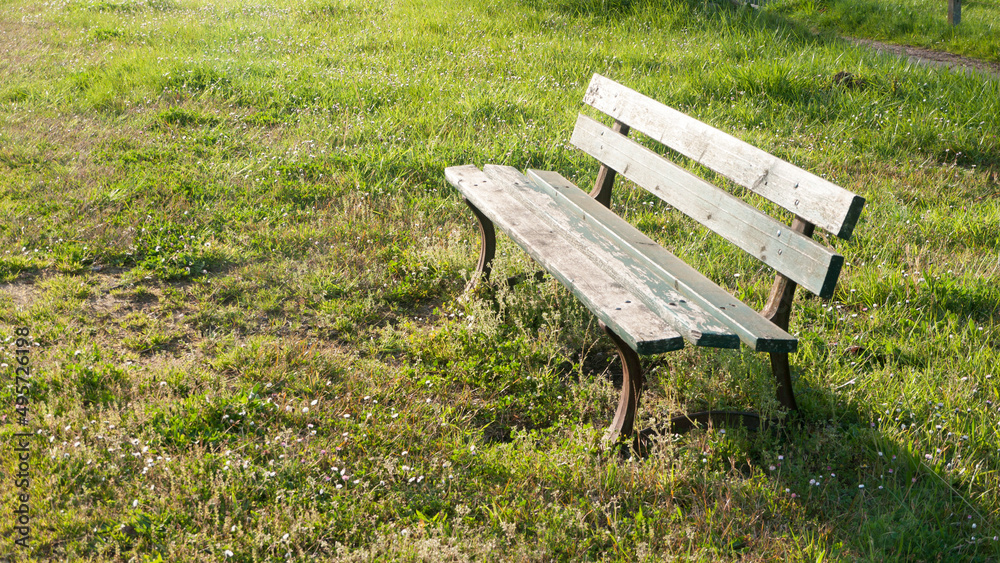 Banco rústico de madera en pradera de hierba verde Banco rústico de madera en pradera de hierba verde