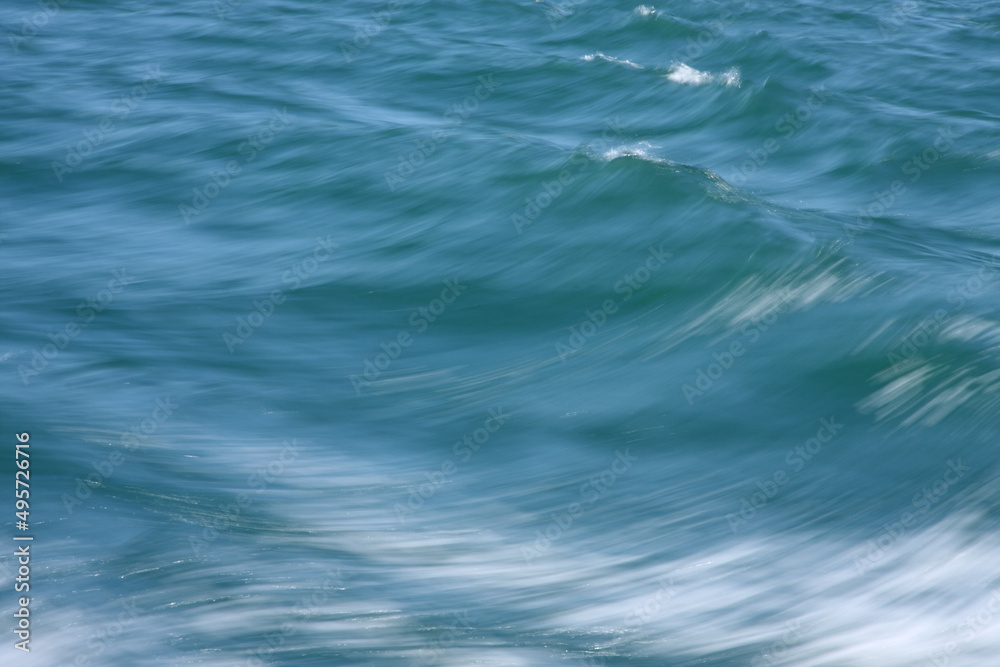 Naklejka premium Blue waves of sea in blurred motion abstract horizontal