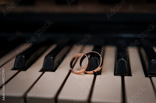 Pair of gold wedding rings on a piano