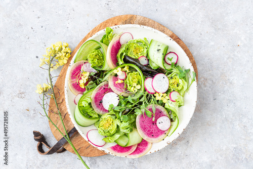 Spring salad with radish, cucumber, lettuce and mustard flowers