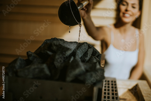 Young woman pouring water o...