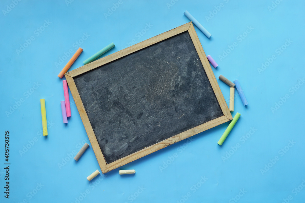 A black chalk board on blue background top view A black chalk board on blue background top view