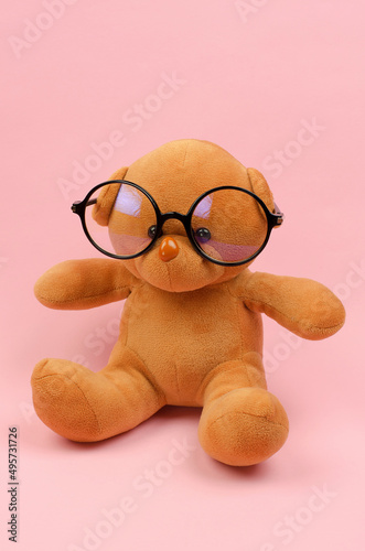 Teddy bear in round black glasses for vision.