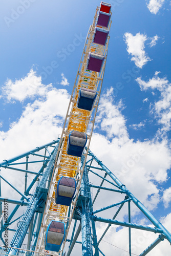 Ferris Wheel is under blue sky on a sunny day. Mtatsminda Park, Tbilisi, Georgia