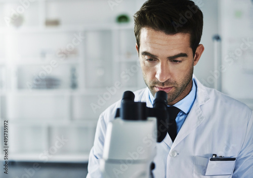 Busy with a new breakthrough. Shot of a scientist using a microscope in a lab.