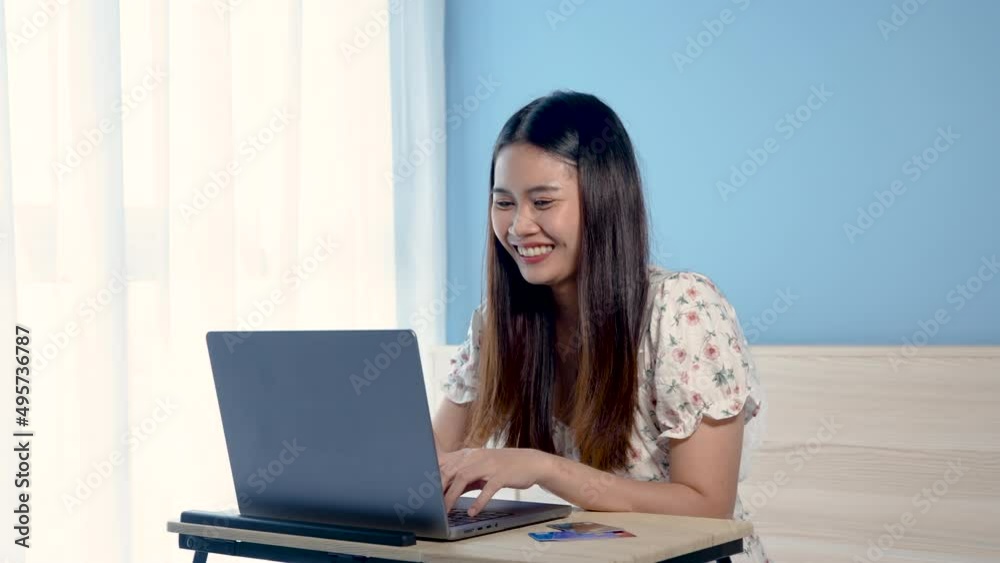 4K 50fps, Beautiful Asian girl,sitting in front of her laptop screen, shopping and ordering online, with a smiling and happy face, on the table are several credit cards,online shopping. 4K 50fps, Beautiful Asian girl,sitting in front of her laptop screen, shopping and ordering online, with a smiling and happy face, on the table are several credit cards,online shopping.