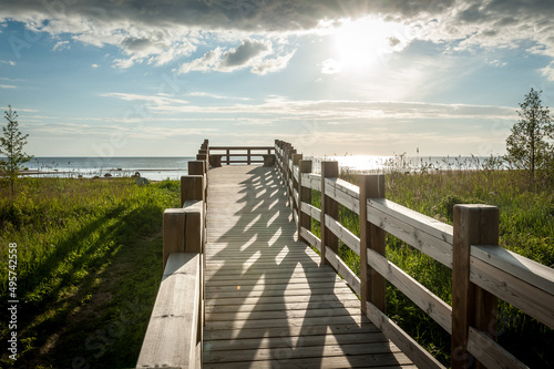 A wooden boardwalk beach access leads through meadow to an observation deck and Baltic beach. Kabli nature study trail. Estonia.