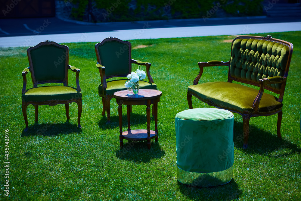 Empty furniture in the park on green grass