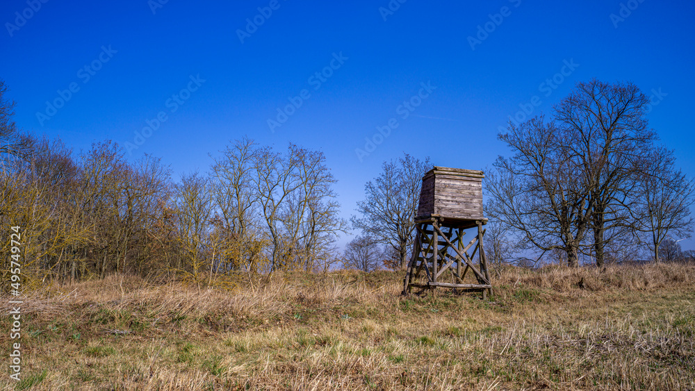 ein Hochsitz auf einem Feld vor blauem Himmel ein Hochsitz auf einem Feld vor blauem Himmel