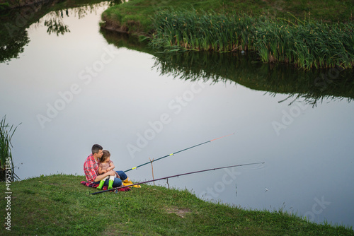 Big beautiful lake. Rear view of father and child on a fishing trip