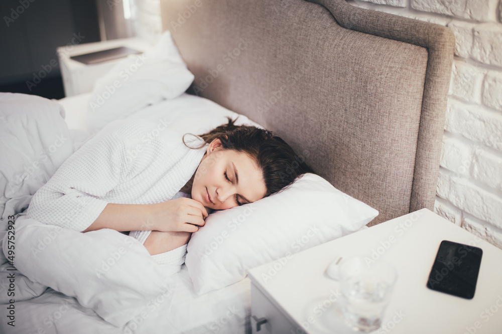 Young woman sleeping in her bed with white linen. Young woman sleeping in her bed with white linen.