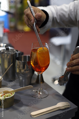 barman preparando coctel con una rodaja de naranja © planeta11