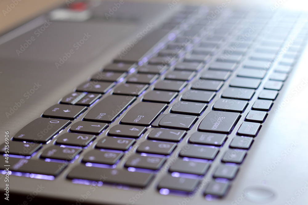 A picture of a computer keyboard with backlight, soft background