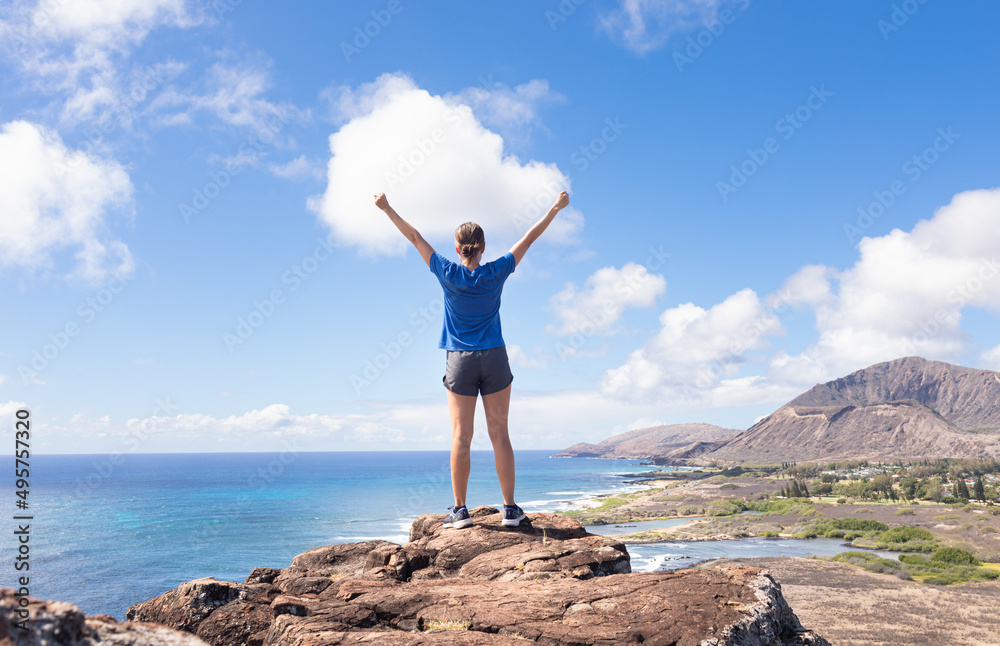 Happy woman on a mountain looking up to the blue sky with arms up. Active healthy lifestyle concept. Happy woman on a mountain looking up to the blue sky with arms up. Active healthy lifestyle concept.