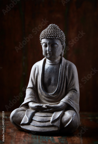 Meditating Buddha Statue on dark wooden background. Close up.