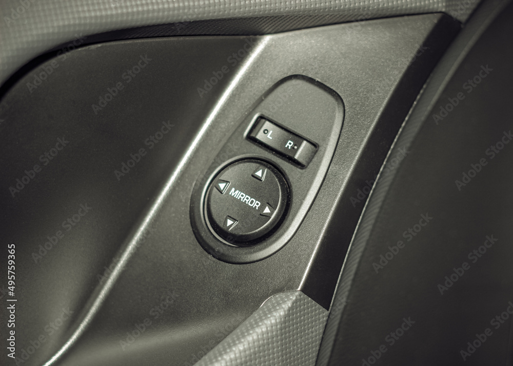 Side mirrors control panel on side door. Car driver adjust side mirror controller. Side mirror control button for adjusting the mirrors. Car door handle. Side mirrors control panel on side door. Car driver adjust side mirror controller. Side mirror control button for adjusting the mirrors. Car door handle.