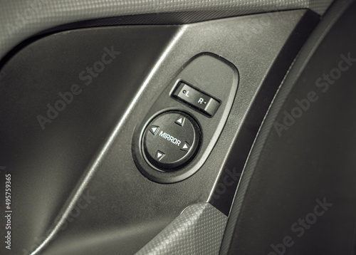 Side mirrors control panel on side door. Car driver adjust side mirror controller. Side mirror control button for adjusting the mirrors. Car door handle. 