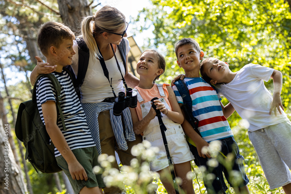 Group of children hiking in the forest with their teacher.They learn ...