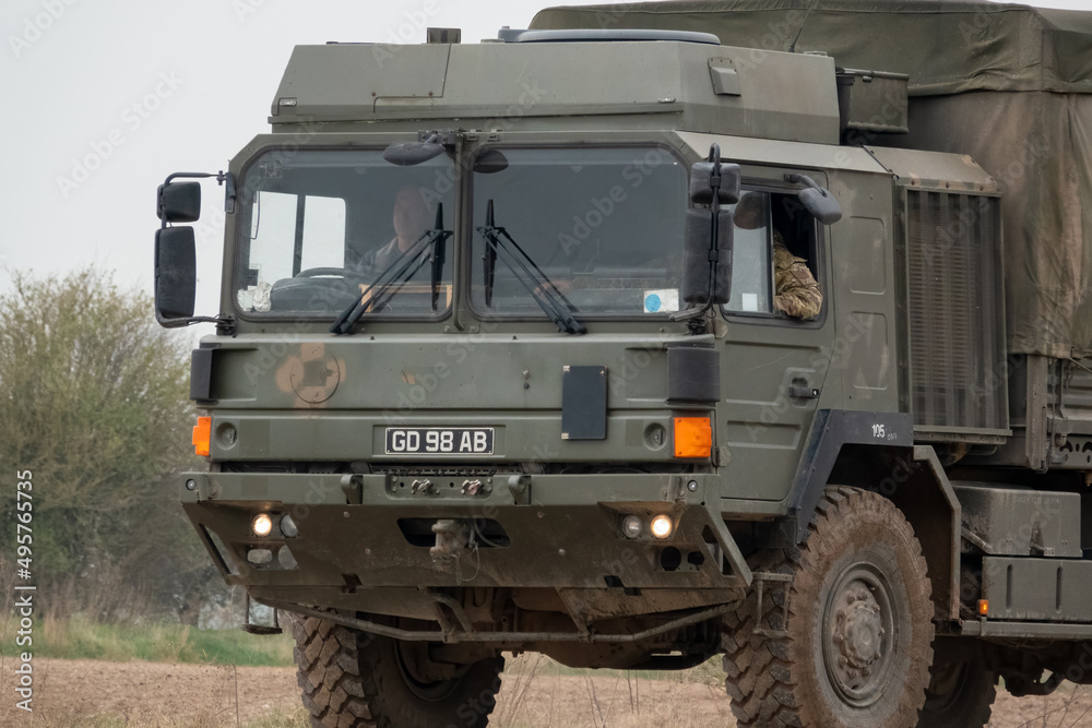 British army MAN SV 4x4 army logistics lorry vehicle truck driving along a dirt track in action on a military exercise British army MAN SV 4x4 army logistics lorry vehicle truck driving along a dirt track in action on a military exercise