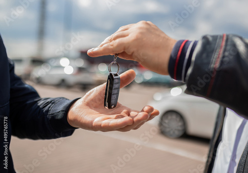Сlose up. Hand giving a car key. Concept of successful car transaction sale-purchase deal