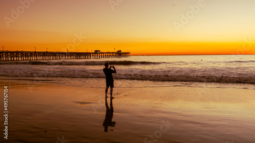 Silhouette of a guy taking a landscape picture of the san clement seashore sunset photo