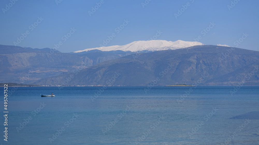 Mount Parnassus covered in snow as seen from traditional and picturesque village of Galaxidi famous for marine history and neoclassic architecture, Greece