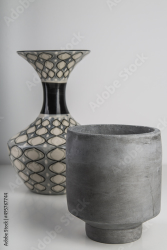 Selective focus shot of a small grey ceramic vase and another one with a pattern on the background photo