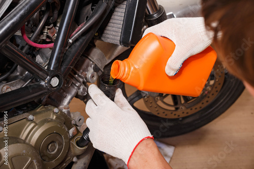 The process of pouring new oil into the motorcycle engine.