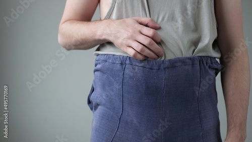 Badly dressed man is scratching his belly