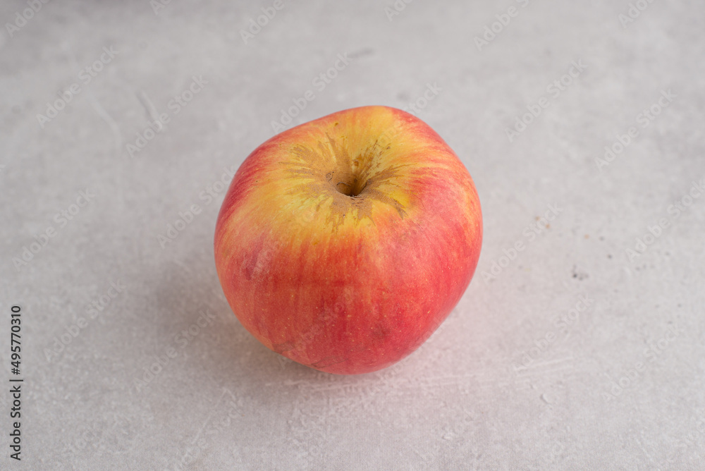 Fresh red apple on grey background. Food ingredients for healthy eating lifestyle Fresh red apple on grey background. Food ingredients for healthy eating lifestyle