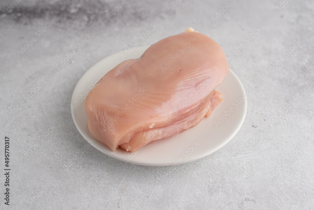 Lean chicken fillet on a gray background. A food ingredient for a healthy lifestyle and dietary cooking Lean chicken fillet on a gray background. A food ingredient for a healthy lifestyle and dietary cooking