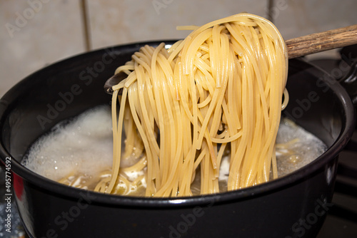 Closeup shot of a cooked pasta bieng taken off from photo