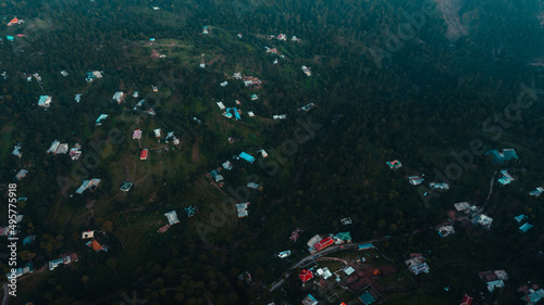 Aerial view of beautiful homes in green hills surrounded by trees 
