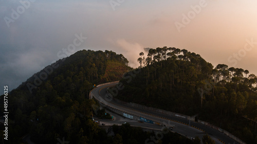 Aerial view of beautiful homes in green hills surrounded by trees 